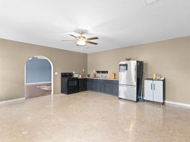 kitchen featuring stainless steel fridge, ceiling fan, and black range with electric cooktop