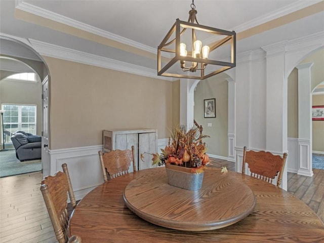 dining room featuring hardwood / wood-style floors, a tray ceiling, ornamental molding, and a chandelier