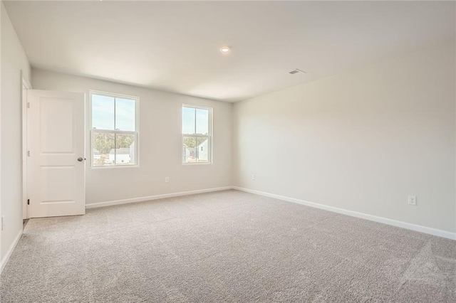 carpeted empty room featuring baseboards