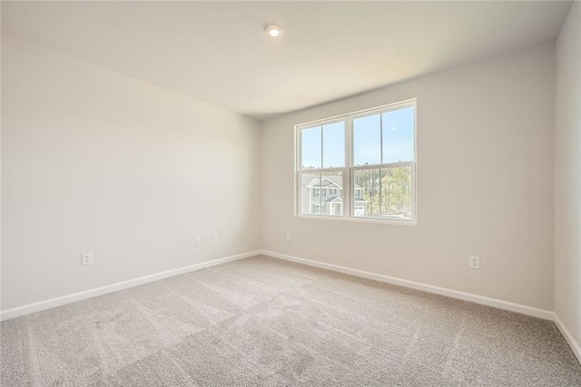 spare room featuring baseboards and carpet flooring
