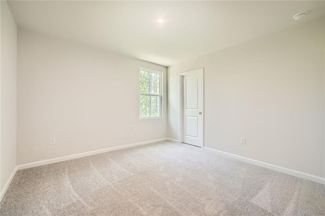 empty room with baseboards and light carpet