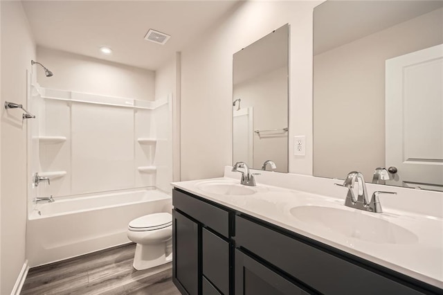 full bath featuring toilet, visible vents, wood finished floors, and a sink