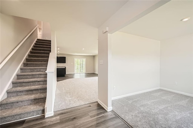 stairway featuring wood finished floors, baseboards, and recessed lighting