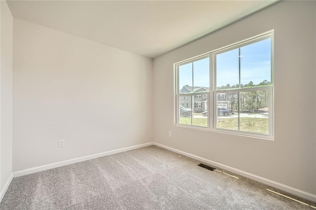 carpeted empty room with baseboards and visible vents