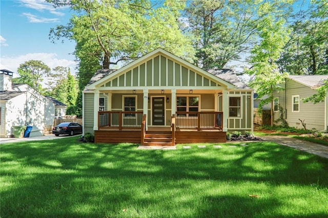 bungalow-style house with a porch, a front lawn, and a shingled roof