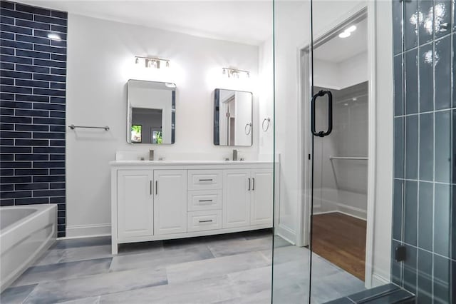 bathroom with a bath, double vanity, baseboards, and a shower