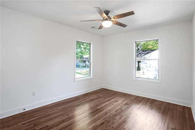 empty room featuring dark wood-type flooring, baseboards, and ceiling fan