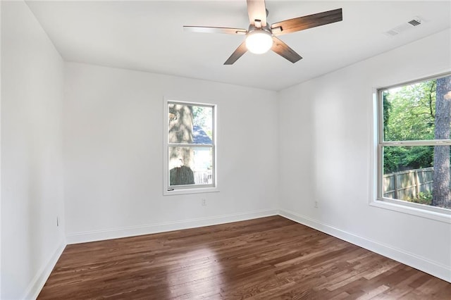 spare room featuring plenty of natural light, dark wood-style flooring, and ceiling fan