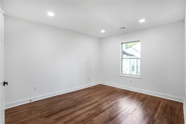 spare room with dark wood finished floors, baseboards, and recessed lighting