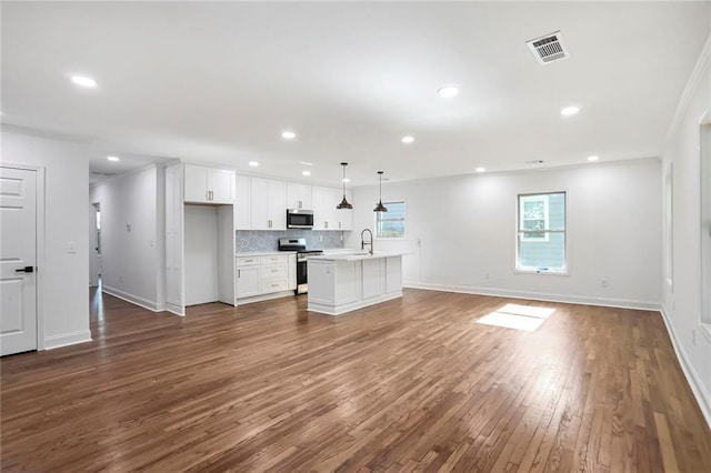 unfurnished living room with a sink, dark wood finished floors, baseboards, and recessed lighting