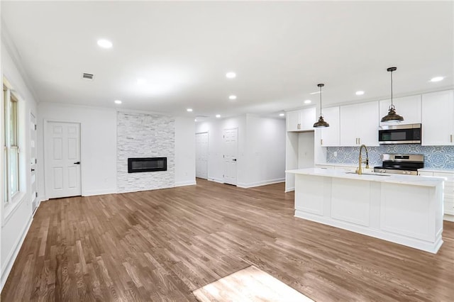 kitchen featuring appliances with stainless steel finishes, a sink, backsplash, recessed lighting, and light countertops