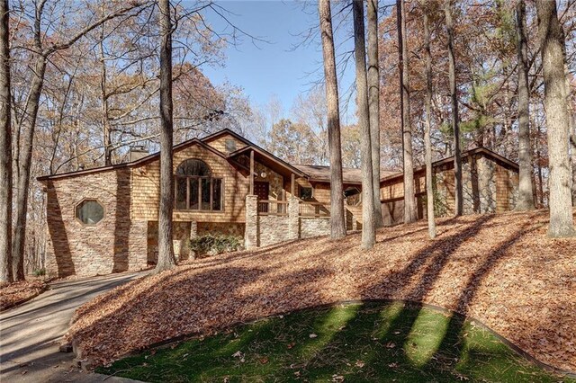 exterior space featuring stone siding and a chimney