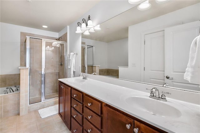 bathroom featuring tile patterned flooring, shower with separate bathtub, and vanity