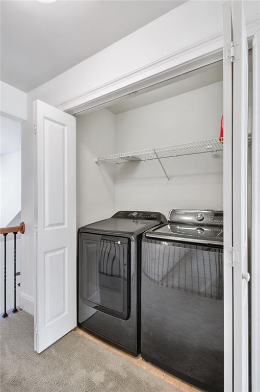 laundry area with light colored carpet and independent washer and dryer