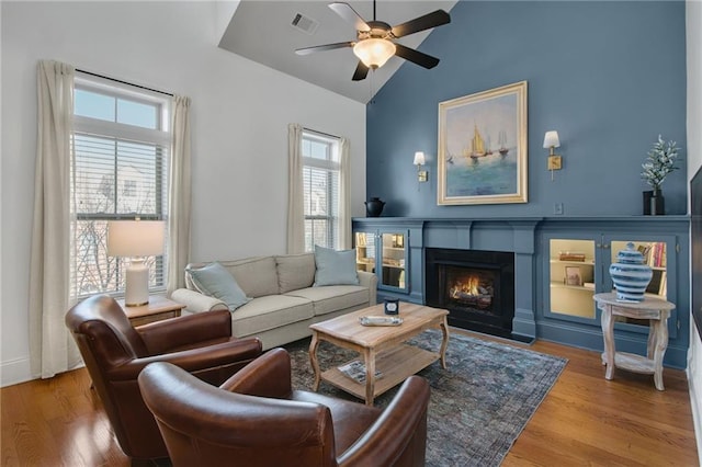 living room featuring high vaulted ceiling, hardwood / wood-style floors, and ceiling fan