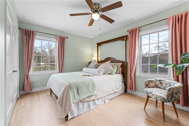 bedroom featuring light wood-type flooring, ceiling fan, and baseboards