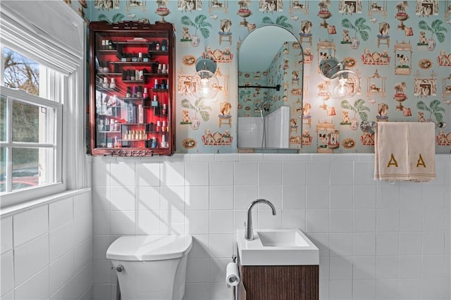 bathroom featuring wainscoting, vanity, toilet, and wallpapered walls