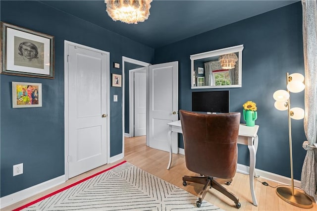 home office featuring a notable chandelier, baseboards, and wood finished floors