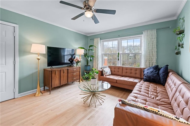 living room featuring ornamental molding, light wood-style floors, baseboards, and a ceiling fan