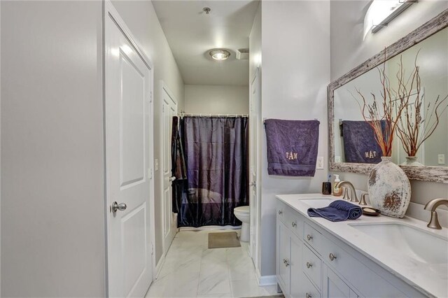 bathroom featuring double sink vanity, tile patterned flooring, and toilet