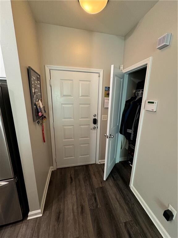 corridor with dark hardwood / wood-style flooring