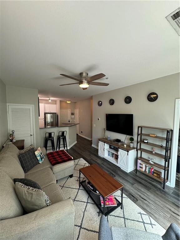 living room featuring hardwood / wood-style floors and ceiling fan