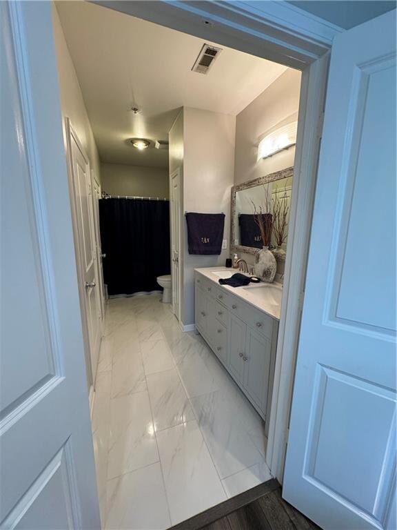 bathroom featuring toilet, vanity, and tile patterned flooring