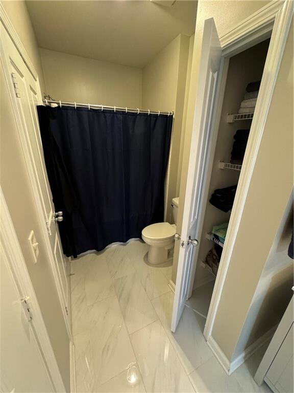 bathroom featuring toilet and tile patterned flooring