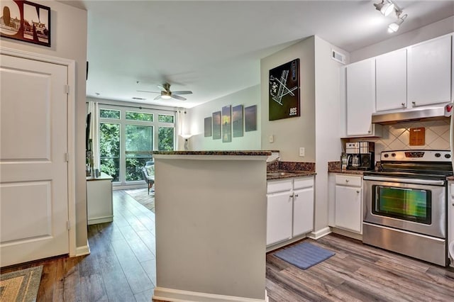 kitchen featuring electric range, hardwood / wood-style flooring, dark stone counters, ceiling fan, and kitchen peninsula