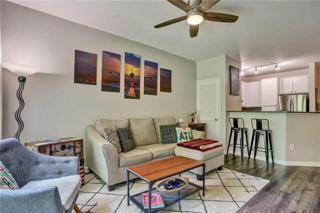 living room with rail lighting, ceiling fan, and wood-type flooring