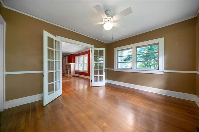 1276 Lanier Blvd NE, Atlanta, GA 30306 - unfurnished room featuring baseboards, crown molding, wood finished floors, a ceiling fan, and french doors