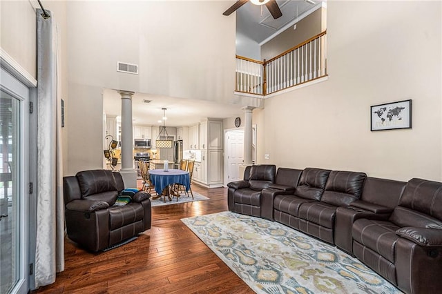 3117 Blowing Wind Ct NW, Acworth, GA 30101 - living area with decorative columns, a ceiling fan, a high ceiling, and dark wood finished floors