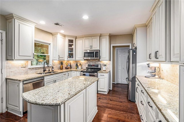 3117 Blowing Wind Ct NW, Acworth, GA 30101 - kitchen with appliances with stainless steel finishes, decorative backsplash, light stone countertops, a center island, and recessed lighting