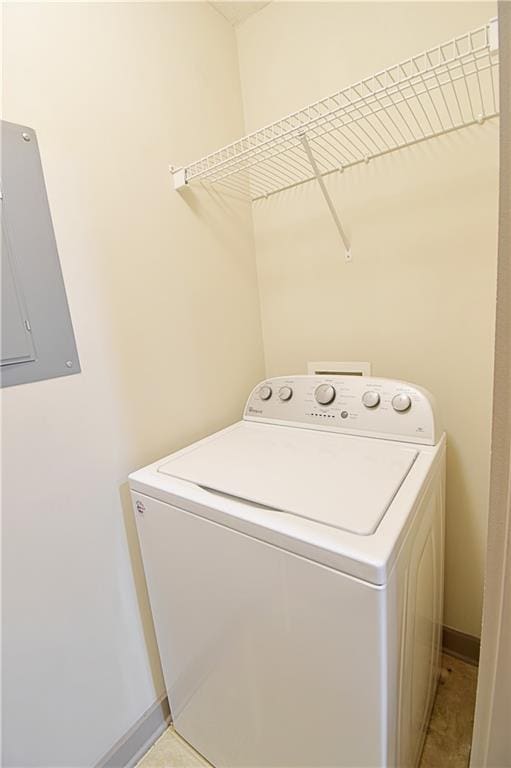 clothes washing area with washer / dryer, electric panel, baseboards, and laundry area