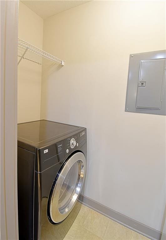 washroom with electric panel, laundry area, washer / dryer, and baseboards