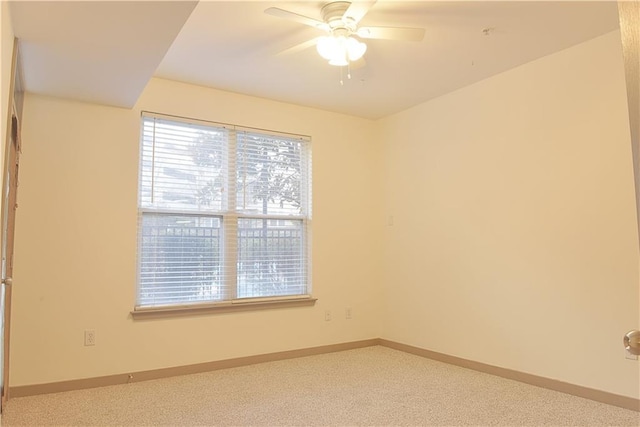 empty room featuring baseboards, carpet floors, and ceiling fan