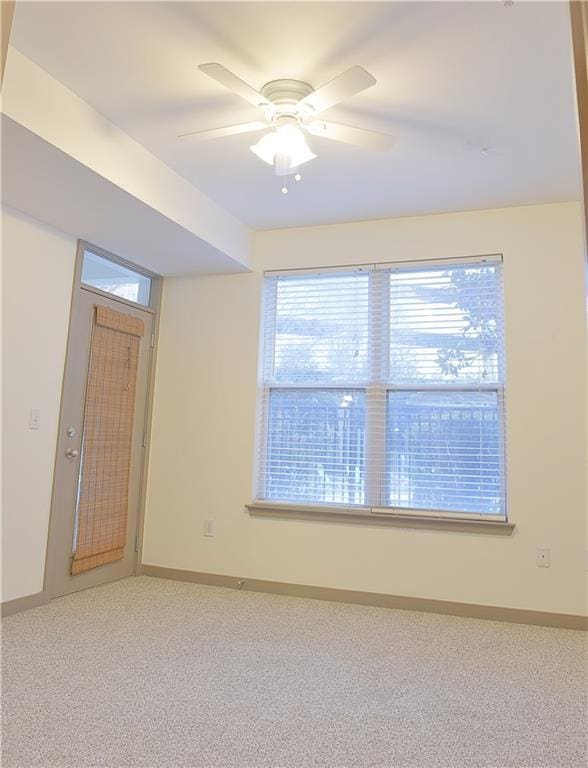 unfurnished room featuring light carpet, a healthy amount of sunlight, and ceiling fan