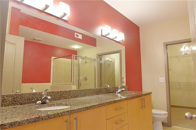 bathroom with a shower stall, double vanity, visible vents, and a sink