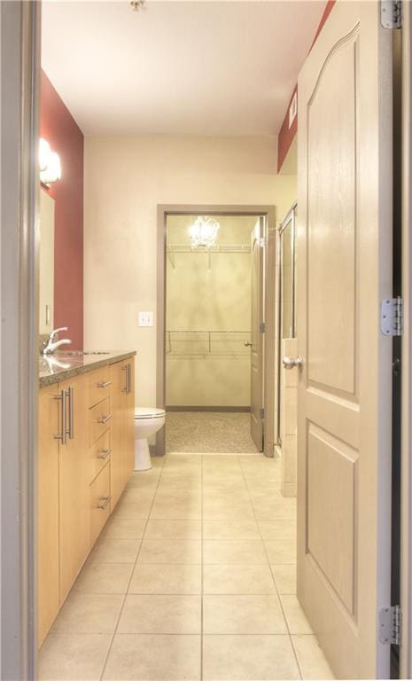 bathroom with tile patterned flooring, toilet, and vanity