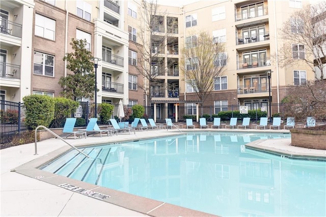 view of swimming pool featuring fence