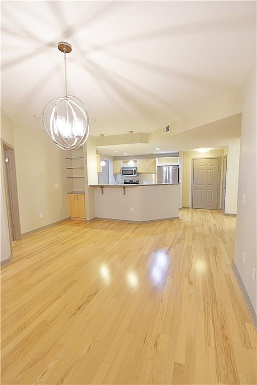 unfurnished living room featuring a chandelier, visible vents, light wood-type flooring, and baseboards