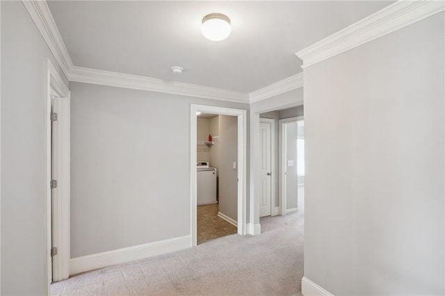 corridor with washer / dryer, carpet flooring, crown molding, and baseboards