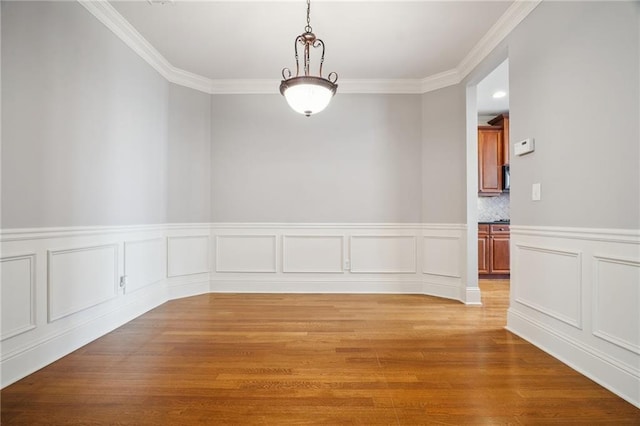 empty room featuring crown molding and light wood-type flooring