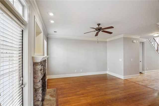 unfurnished living room with baseboards, crown molding, a ceiling fan, and light wood finished floors