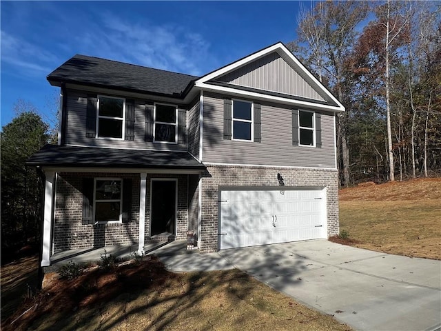 view of front of property featuring a porch, a front yard, and a garage