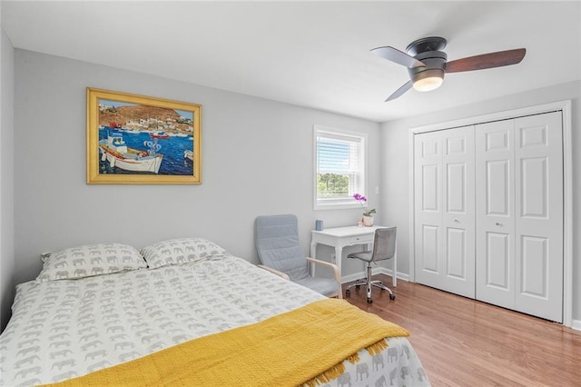 bedroom featuring wood finished floors, a closet, a ceiling fan, and baseboards