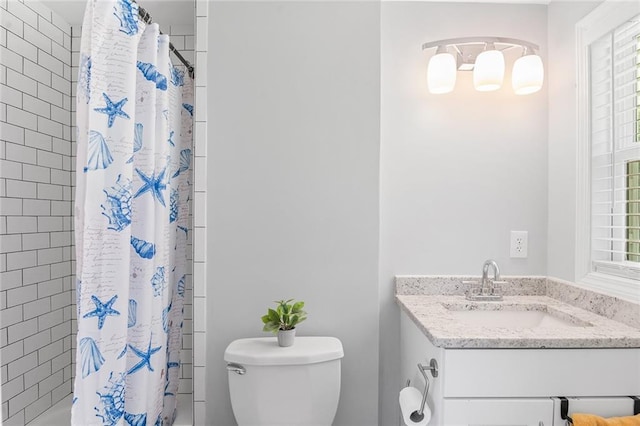 bathroom with a healthy amount of sunlight, toilet, shower / bath combo, and vanity
