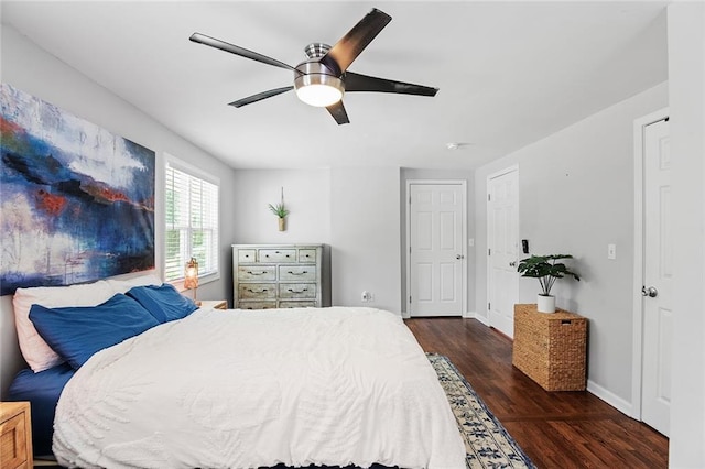 bedroom with baseboards, a ceiling fan, and dark wood-style floors