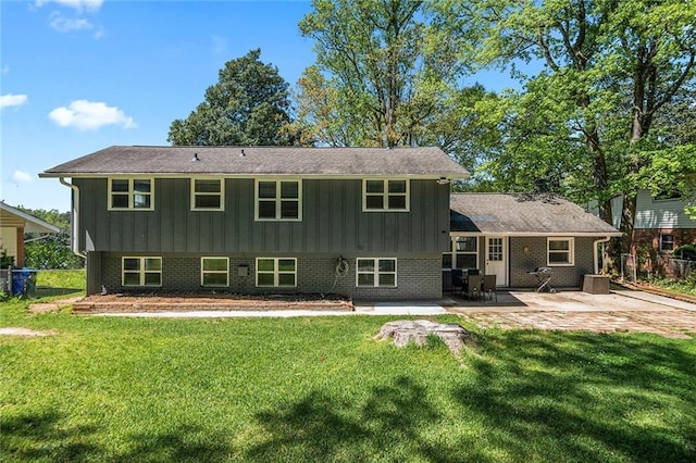 rear view of house featuring a lawn, a patio, and board and batten siding