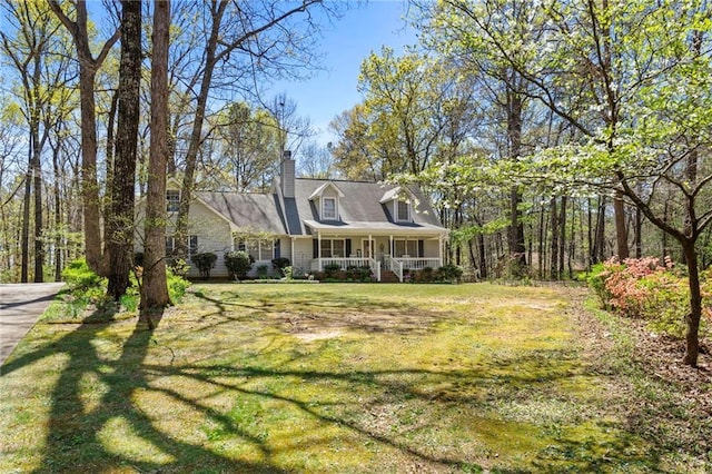 cape cod home with a front lawn and covered porch